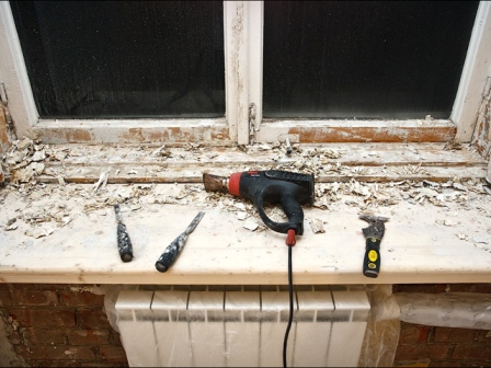 Используя монтажный фен, очищаем деревянные окна от краски
